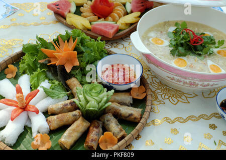 Famille vietnamienne pour repas de semaine avec crap soupe, vermicelles de riz et des rouleaux de printemps frits, des fruits pour le dessert, si délicieux de nourriture de table Banque D'Images