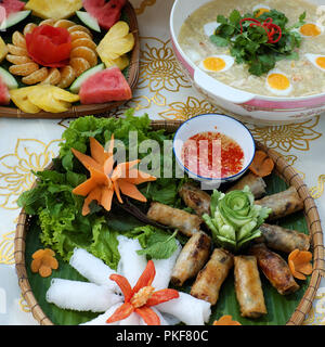 Famille vietnamienne pour repas de semaine avec crap soupe, vermicelles de riz et des rouleaux de printemps frits, des fruits pour le dessert, si délicieux de nourriture de table Banque D'Images