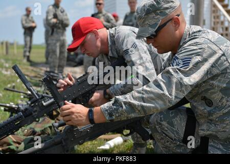 Le s.. Dylan Burke et Senior Airman Aaron Collins, spécialistes des armes de combat avec le 155e Escadron des Forces de sécurité, inspecter le M240B machine gun 7 août 2018, à l'Army National Guard's Formation Greenlief Site, près de Hastings, Nebraska. Banque D'Images