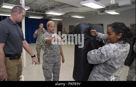 U.S. Air Force d'un membre de la 1re classe Casey Atanasio, centre, un coordonnateur des déplacements de patients affectés à la 6e Escadron de soutien médical, apprend à bonne distance et de la forme pour baton frappe à la base aérienne MacDill, Floride, 25 juillet 2018. Atanasio a participé à une semaine de 6ème classe que les forces de sécurité des trains tireur d'aviateurs dans divers champs professionnels sur les procédures de sécurité en cas d'urgence ou d'imprévu. Banque D'Images