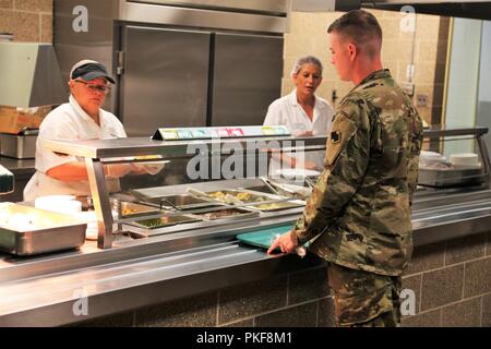 Un soldat reçoit une assiette de nourriture à partir d'un employé de l'entrepreneur avec DCT Inc. le 3 août 2018, dans la salle à manger dans le bâtiment 50 à Fort McCoy, Wisconsin chaque fois un grand exercice comme un exercice d'entraînement de soutien au combat a lieu à Fort McCoy, des milliers de troupes ont besoin d'être nourris. L'installation des services de restauration de l'équipe veille à ce que le besoin est toujours atteinte. Cette équipe comprend le Bureau de gestion du programme alimentaire et la gestion de l'offre de séjour avec l'Office de Fort McCoy Centre de préparation logistique ; la totalité des services alimentaires Inc. ; et l'entrepreneur DCT fournisseurs de produits alimentaires, tels que Sysco Foods de Baraboo, Wisconsin Banque D'Images