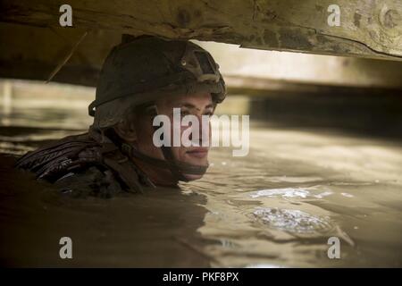 Le Sgt. Jose Gutierrez, un carabinier avec Echo, l'entreprise Équipe de débarquement du bataillon, 2e Bataillon, 5ème Marines, manoeuvres à travers une tranchée inondée pendant un cours d'endurance au Jungle Warfare Training Center, Camp Gonsalves, Okinawa, Japon, Juillet 30, 2018. Gutierrez, originaire de Pheonix, enrôlé de recruter substation Joplin, avant de partir pour la formation de base en août 2012. Les marines formés à se préparer à une ETFC patrouille à venir de la région indo-pacifique comme l'élément de combat terrestre pour la 31e Marine Expeditionary Unit. La 31e MEU, le Marine Corps' seulement continuellement de l'avant-déployé Banque D'Images