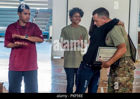 KOROR, Palau (16 août 2000 10, 2018) Hannah Anderson, l'équipe d'action civique (CAT) Palau apprenti-électricien, étreintes Sgt. 1re classe Wesley Greer, CAT 84-05 Sous-officier responsable, après la présentation de son diplôme d'apprenti pendant le chat de changer de Palau cérémonie. CAT 84-05 a formé 12 apprentis palaosienne à toute une gamme de constructions, d'administration, l'utilisation de machinerie lourde et de menuiserie, avec sept disciplines complété avec succès leur formation et diplômés du programme. Au cours de la cérémonie, CAT 84-05 l'armée a été relevé par la U.S. Air Force CAT 36-03. La Loi sur la citoyenneté Banque D'Images