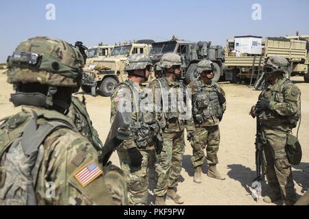 Le colonel James McCormack, commandant de groupe, le Lieutenant-colonel David Marous, commande de la section des opérations et le Sgt. Le major Andrew Campbell, de la 213e groupe d'appui régional, New York Garde nationale, parler avec des soldats de la compagnie de composite 1067th 9 août au Centre National d'entraînement, Fort Irwin, en Californie, l'état-major a visité le 1067th pour revoir les opérations, se connecter avec des soldats et relever le moral pendant la tâche ardue d'instruction au CNT. Banque D'Images