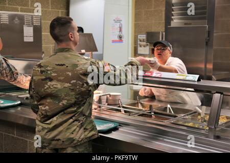 Un soldat reçoit une assiette de nourriture à partir d'un employé de l'entrepreneur avec DCT Inc. le 3 août 2018, dans la salle à manger dans le bâtiment 50 à Fort McCoy, Wisconsin chaque fois un grand exercice comme un exercice d'entraînement de soutien au combat a lieu à Fort McCoy, des milliers de troupes ont besoin d'être nourris. L'installation des services de restauration de l'équipe veille à ce que le besoin est toujours atteinte. Cette équipe comprend le Bureau de gestion du programme alimentaire et la gestion de l'offre de séjour avec l'Office de Fort McCoy Centre de préparation logistique ; la totalité des services alimentaires Inc. ; et l'entrepreneur DCT fournisseurs de produits alimentaires, tels que Sysco Foods de Baraboo, Wisconsin Banque D'Images