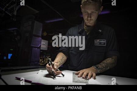 Mer (Aug. 11, 2018) Spécialiste des opérations 1re classe Jacob Smith signifie regarder dans le centre d'information de combat à bord de la classe Arleigh Burke destroyer lance-missiles USS Carney (DDG 64), le 11 août 2018. Carney, l'avant-déployé à Rota, en Espagne, est sur sa cinquième patrouille dans la sixième flotte américaine zone d'opérations à l'appui d'alliés et de partenaires régionaux ainsi que les intérêts de sécurité nationale des États-Unis en Europe et en Afrique. Banque D'Images