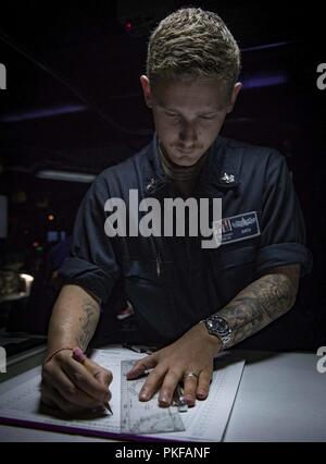 Mer (Aug. 11, 2018) Spécialiste des opérations 1re classe Jacob Smith signifie regarder dans le centre d'information de combat à bord de la classe Arleigh Burke destroyer lance-missiles USS Carney (DDG 64), le 11 août 2018. Carney, l'avant-déployé à Rota, en Espagne, est sur sa cinquième patrouille dans la sixième flotte américaine zone d'opérations à l'appui d'alliés et de partenaires régionaux ainsi que les intérêts de sécurité nationale des États-Unis en Europe et en Afrique. Banque D'Images