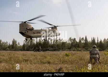 Soldats avec Batterie B, 1er Bataillon, 103e Régiment d'artillerie de la Garde nationale de Rhode Island, effectuer une opération de chargement de l'élingue pour un obusier M777 au Camp Grayling, Mich., le 10 août 2018. Le 103e FA participe à Northern Strike, une multinationale interarmées exercice de tir réel d'armes combinées impliquant environ 5 000 militaires de 11 membres et de six pays de la coalition. Banque D'Images