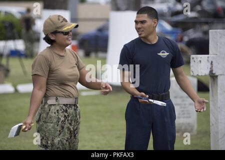 PORT OF SPAIN, Trinité-et-Tobago (16 août 2000 10, 2018) Le lieutenant Cmdr. Catherine Corbett, un agent en poste sur le Island-Class Whidbey Landing Ship Dock USS Gunston Hall (LSD 44), parle d'une Trinité-et-Tobago membre de la garde de l'air au cours d'une relation communautaire événement à un cimetière militaire à Port d'Espagne. Le navire est en déploiement des Mers du Sud, qui est un déploiement de collaboration annuel dans le U.S. Southern Command zone de responsabilité où un groupe se déployer pour effectuer une variété d'exercices et échanges multinationales d'accroître l'interopérabilité, d'accroître la stabilité régionale, et Banque D'Images