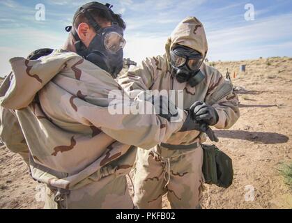 Réserve de l'armée de la CPS. Axel Alvarado (à droite), un produit chimique, biologique, radiologique et nucléaire (CBRN) et originaire de Springdale, Arkansas affecté à la 379e compagnie de produits chimiques, de produits chimiques, 209e Bataillon 472nd Groupe de soutien régional, 76e de l'intervention opérationnelle, aide Commande Pvt. 1re classe Andrew Johnson, un infirmier et originaire de Mililani, New York affecté à la 501e Bataillon de soutien de la Brigade, 1ère Brigade, 1st Armored Division avec retrait de sa mission de protection axé sur la posture (MOPP) au cours des opérations de dépollution à Orogrande, Nouveau Mexique, le 8 août. Près de 50 soldats du 3 Banque D'Images