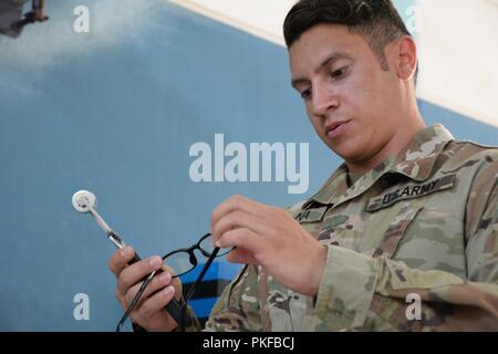 Le sergent de l'armée américaine. Jorge Laguna, un spécialiste de laboratoire d'optique et le sergent du détachement pour le 166e détachement médical, inspecte une paire de lunettes pour un patient de soins Tropic Maui County 2018 PFC à Anthony T. Kahoohanohano Armory près de Kihei, Hi. Le 11 août 2018. Soins Tropic 2018 Maui County est une joint-service, pratique à la mission de formation de préparation à l'offrant pas de frais médicaux, dentaires, et la vision des services aux personnes à six endroits de Maui, Molokai et Lanai d'août 11-19. Banque D'Images