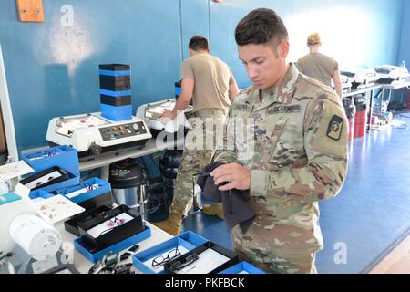 Le sergent de l'armée américaine. Jorge Laguna, un spécialiste de laboratoire d'optique et le sergent du détachement pour le 166e détachement médical, nettoie une paire de lunettes pour un patient de soins Tropic Maui County 2018 PFC à Anthony T. Kahoohanohano Armory près de Kihei, Hi. Le 11 août 2018. Soins Tropic 2018 Maui County est une joint-service, pratique à la mission de formation de préparation à l'offrant pas de frais médicaux, dentaires, et la vision des services aux personnes à six endroits de Maui, Molokai et Lanai d'août 11-19. Banque D'Images