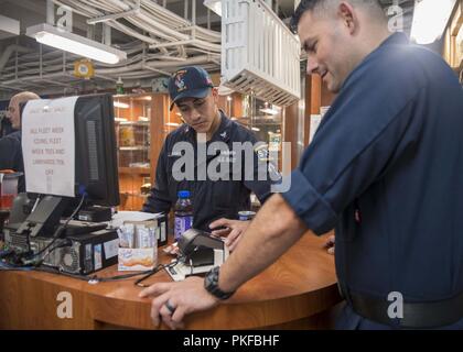 Océan (3 août 2018) - 3e classe veteran du navire Fernando Villarreal aide un client dans le magasin du navire de classe Wasp-navire d'assaut amphibie USS Essex (DG 2) lors d'un déploiement prévu de la Essex Groupe amphibie (ARG) et 13e Marine Expeditionary Unit (MEU). L'Essex ARG/13e MEU est capable d'une mortelle et Navy-Marine Corps équipe déployée à la 7e flotte zone d'opérations pour soutenir la stabilité régionale, de rassurer les partenaires et alliés et maintenir une présence postured à répondre à n'importe quelle crise allant de l'aide humanitaire aux opérations de contingence. Banque D'Images