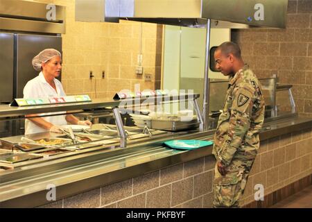 Un soldat reçoit une assiette de nourriture à partir d'un employé de l'entrepreneur avec DCT Inc. le 3 août 2018, dans la salle à manger dans le bâtiment 50 à Fort McCoy, Wisconsin chaque fois un grand exercice comme un exercice d'entraînement de soutien au combat a lieu à Fort McCoy, des milliers de troupes ont besoin d'être nourris. L'installation des services de restauration de l'équipe veille à ce que le besoin est toujours atteinte. Cette équipe comprend le Bureau de gestion du programme alimentaire et la gestion de l'offre de séjour avec l'Office de Fort McCoy Centre de préparation logistique ; la totalité des services alimentaires Inc. ; et l'entrepreneur DCT fournisseurs de produits alimentaires, tels que Sysco Foods de Baraboo, Wisconsin Banque D'Images