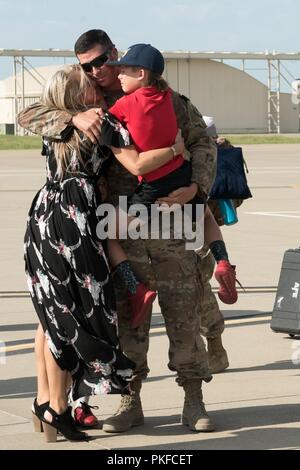 Le s.. Clayton Stephens, 138e Escadron de maintenance des aéronefs, embrasse sa famille après son retour de mission, le 5 août 2018, à la base de la Garde nationale aérienne de Tulsa de Tulsa, Oklahoma. Banque D'Images