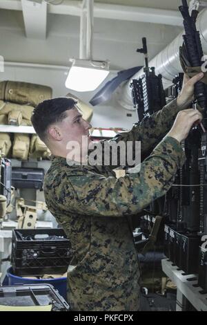 Océan Pacifique - Le Sergent des Marines des États-Unis. Wade Pawlisz, un armurier avec l'élément de commandement, 13e Marine Expeditionary Unit (MEU), vérifie les numéros de série sur les carabines à bord de la classe Wasp-navire d'assaut amphibie USS Essex (DG 2) lors d'un déploiement prévu de la Essex Groupe amphibie (ARG) et la 13e MEU, le 3 août 2018. L'Essex ARG/ 13e MEU est capable d'une mortelle et Navy-Marine Corps équipe déployée à la 7e flotte zone d'opérations pour soutenir la stabilité régionale, de rassurer les partenaires et alliés et maintenir une présence postured à répondre à n'importe quelle crise allant de l'aide humanitaire Banque D'Images