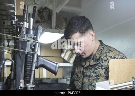 Océan Pacifique - Le Sergent des Marines des États-Unis. Wade Pawlisz, un armurier avec l'élément de commandement, 13e Marine Expeditionary Unit (MEU), vérifie les numéros de série lors du lancement de gear à bord de la classe Wasp-navire d'assaut amphibie USS Essex (DG 2), lors d'un déploiement prévu de la Essex Groupe amphibie (ARG) et la 13e MEU, le 3 août 2018. L'Essex ARG/ 13e MEU team est un est un capable et létales Navy-Marine Corps force déployée à la 7e flotte zone d'opérations pour soutenir la stabilité régionale, de rassurer les partenaires et alliés et maintenir une présence postured à répondre à n'importe quelle crise allant en arrière Banque D'Images