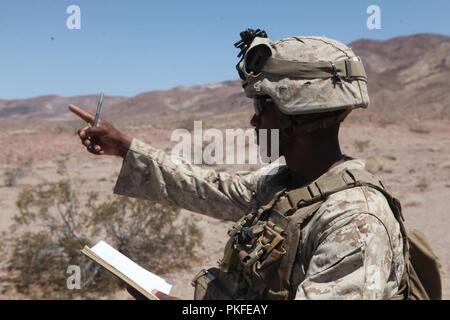 Un U.S. Marine avec 3e Bataillon, 6e Régiment de Marines commandes appels à une section de mortarmen au cours de l'exercice de formation intégrée (ITX) 5-18 au Marine Corps Air Ground Combat Center Twentynine Palms, en Californie le 3 août 2018. L'ITX est une grande échelle air-sol marin l'exercice d'intégration du groupe de travail qui vise à préparer les Marines et les marins de 3/6 pour les imprévus. Banque D'Images