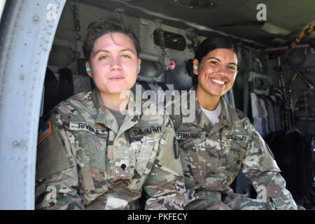 La CPS. Kristina Rivera et le Cpl. Maria Fernandez à la fois avec la Compagnie Alpha, 250e Bataillon de soutien de la Brigade de la Teaneck Armory se préparer à une ride. helo Réengagés récemment des soldats de la Garde nationale du New Jersey ont eu droit à un vol d'incitation à bord d'un Blackhawk UH60, 10 août 2018 au Centre de formation de la Garde nationale dans la région de Sea Girt, New Jersey. Pour honorer leur engagement à la Garde nationale du New Jersey, ces soldats ont eu l'occasion de voler à bord de l'hélicoptère pendant que les pilotes menées nap-de-la-terre formation aérienne. Banque D'Images