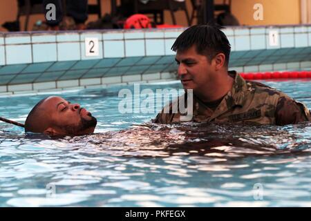 Le s.. Jose Palacios, chef d'équipe avec la Garde nationale de Floride, du CERFP aide un membre de la formation de l'eau rapide au cours de VKC à Marine Base Parera, Willemstad, Curaçao, 1-2 août, 2018. Les députés de l'FLARNG est arrivée à Curaçao pour soutenir un échange d'informations avec la VKC pour se concentrer sur les meilleures pratiques en matière de recherche et de sauvetage (SAR) et les tactiques d'intervention médicale. Banque D'Images