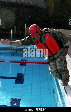 Le s.. Jose Palacios, chef d'équipe avec la Garde nationale de Floride, du CERFP aide un membre de la formation de l'eau rapide au cours de VKC à Marine Base Parera, Willemstad, Curaçao, 1-2 août, 2018. Les députés de l'FLARNG est arrivée à Curaçao pour soutenir un échange d'informations avec la VKC pour se concentrer sur les meilleures pratiques en matière de recherche et de sauvetage (SAR) et les tactiques d'intervention médicale. Banque D'Images