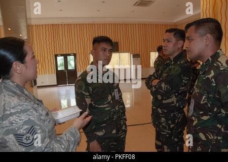 Tech. Le Sgt. Franchesa Pau'u, 169e Escadron de défense aérienne contrôleur des armes des entretiens avec un groupe d'aviateurs de l'Armée de l'Air Philippine, le 6 août 2018, Villamor Air Base, Manille, Philippines. Pau'u et d'autres membres de la California Air National Guard prenant part à un échange d'experts en la matière avec le PAF dans le cadre d'un programme de partenariat de l'état de la Garde nationale de l'engagement. Banque D'Images