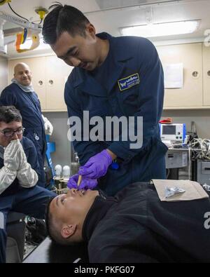 Océan Pacifique (Juillet 28, 2018) Hospital Corpsman 2e classe Andrew Kim, de Fullerton, Californie, procède à la formation médicale dans le service de médecine de San Antonio-classe de transport amphibie USS dock Anchorage (LPD 23) lors d'un déploiement prévu d'Essex Groupe amphibie (ARG) et 13e Marine Expeditionary Unit (MEU). L'Essex ARG/MEU team est une force solide et souple et évolutive équipée pour répondre à n'importe quelle crise allant de l'aide humanitaire et des secours aux opérations de contingence. Banque D'Images