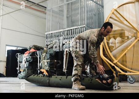 Le s.. Michael Galindo, 320th Special Tactics Squadron pararescueman, démontre les soins aux patients utilisés pendant le transport de 12 jeunes joueurs de football et leur entraîneur, d'une cave inondée en Thailande, le 10 août 2018, à Kadena Air Base, au Japon. Une équipe de recherche et sauvetage ont été envoyés à Tham Luang cave dans le Nord de la Thaïlande, à la demande du Gouvernement royal thaïlandais pour aider au sauvetage de l'absence de joueurs de football thaïlandais et leur entraîneur. Banque D'Images