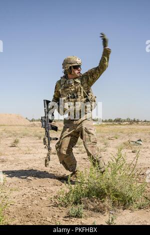 La CPS de l'armée américaine. Bukoiemski, avec des troupes de bandits, 3e régiment de cavalerie, des signaux à ses coéquipiers de se déplacer pendant un exercice de tir réel de forces interarmées au Camp Taji, Iraq, août, 10, 2018. Une coalition créée à partir d'une vaste communauté internationale poursuivra son soutien à la population de l'Iraq afin de renforcer les capacités de la nation d'assurer la sécurité et la stabilité. Banque D'Images