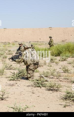 Des soldats américains, avec des troupes de bandits, 3e régiment de cavalerie, réagir à des contacts au cours d'un exercice de tir réel des forces combinées au Camp Taji, Iraq, août, 10, 2018. Une coalition créée à partir d'une vaste communauté internationale poursuivra son soutien à la population de l'Iraq afin de renforcer les capacités de la nation d'assurer la sécurité et la stabilité. Banque D'Images