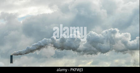 La pollution atmosphérique causée par l'usine. L'épaisse fumée qui sort de la cheminée. Banque D'Images