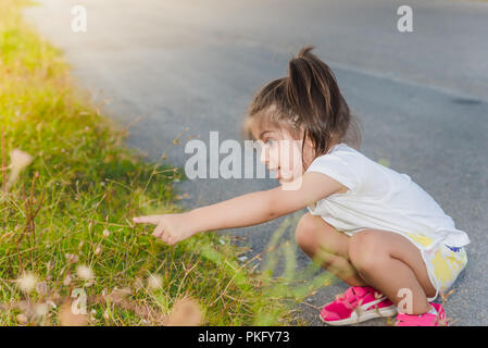 Portrait of cute little girl montrant les escargots sur une plante avec son doigt dans la journée Banque D'Images