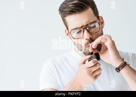 Beau barbu dans les verres cigare éclairage isolé sur fond blanc Banque D'Images