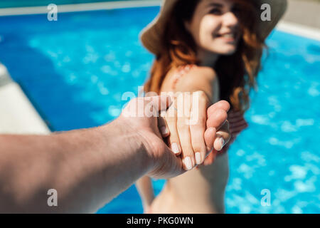 Cropped shot of man holding part de son épouse heureuse en piscine, suivez-moi concept Banque D'Images