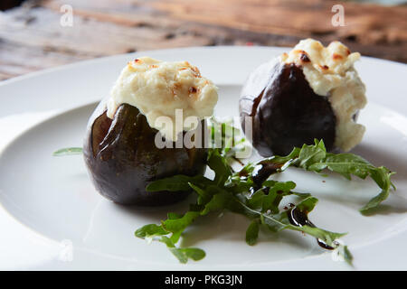 Figues au four avec fromage de chèvre sur des tables en bois. Banque D'Images