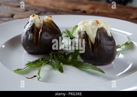 Figues au four avec fromage de chèvre sur des tables en bois. Banque D'Images