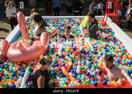 Southbank, Londres, Royaume-Uni, le 13 septembre 2018. Les gens s'amuser avec des boules pour 'Say'ennuyeux dans le soleil de Londres. Prétend être la balle en plein air le plus grand du pit, il s'ouvre sur la Southbank à Londres aujourd'hui. La fosse contient 140 000 boules colorées pour un 'lido' kidult dans lequel les visiteurs pourront se rafraîchir. Credit : Imageplotter News et Sports/Alamy Live News Banque D'Images