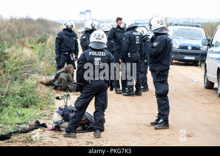 13 septembre 2018, en Rhénanie du Nord-Westphalie, Kerpen : 13 septembre 2018, l'Allemagne, Kerpen : policiers se tiennent devant les militants détenus. Avec une présence policière massive, les autorités de la zone d'exploitation du lignite de Hambach Forest ont commencé à effacer les militants environnementaux' des barricades. Photo : Marcel Kusch/dpa Banque D'Images