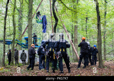 13 septembre 2018, en Rhénanie du Nord-Westphalie, Kerpen : 13 septembre 2018, l'Allemagne, Kerpen : Les agents sont debout devant une barricade dans laquelle un militant lié a elle-même vers le bas. Avec une présence policière massive, les autorités de la zone d'exploitation du lignite de Hambach Forest ont commencé à effacer les militants environnementaux' des barricades. Photo : Marcel Kusch/dpa Banque D'Images