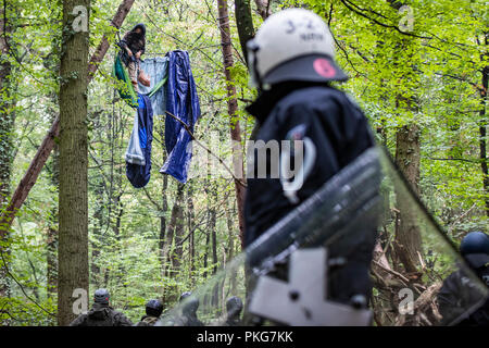 13 septembre 2018, en Rhénanie du Nord-Westphalie, Morschenich : 13 septembre 2018, l'Allemagne, l'Morschenich : Les agents sont debout devant une barricade dans laquelle un militant lié a elle-même vers le bas. Avec une présence policière massive, les autorités de la zone d'exploitation du lignite de Hambach Forest ont commencé à effacer les militants environnementaux' des barricades. Photo : Marcel Kusch/dpa Banque D'Images