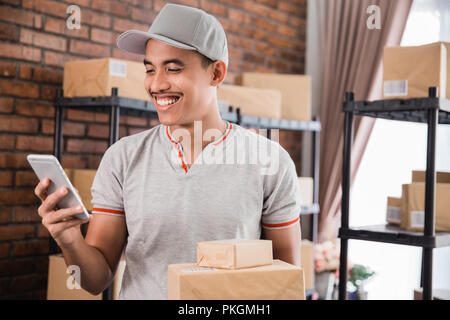 Homme avec un paquet holding smartphone Banque D'Images