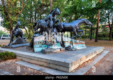 Berlin,Dahlem. Sculpture en bronze de cinq chevaux sauvages sautant au-dessus de vestiges de mur de Berlin. Cadeau de l'USA à RAD commémore le jour où le mur est tombé. Banque D'Images