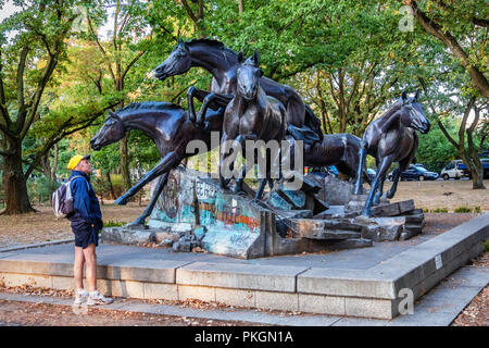 Berlin,Dahlem. Sculpture en bronze de cinq chevaux sauvages sautant au-dessus de vestiges de mur de Berlin. Cadeau de l'USA à RAD commémore le jour où le mur est tombé. Banque D'Images