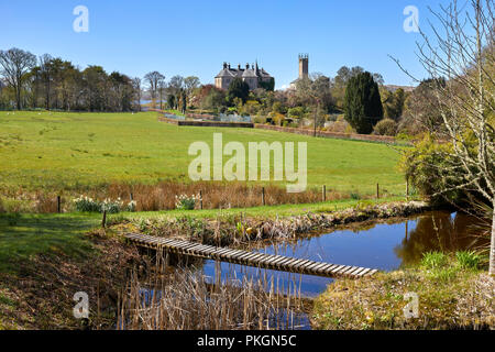 Une vue d'Ardmaddy printemps Château de l'autre à pied et à travers l'étang et passerelle en bois. Seil avec son dans la distance. L'Argyll Banque D'Images