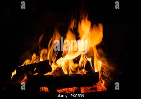 Le bois qui brûle dans la nuit. Au feu de camp touristique à la nature dans les montagnes. Amd flamme feu sur sparks résumé fond sombre. La cuisson barbecue extérieur. Banque D'Images