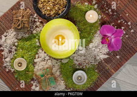 Accessoires Spa avec du savon, orchidée, fleur rouge, bol avec fleurs de camomille séchées, des bouteilles avec de l'huile aromatique, sel de mer, des bougies sur bambou serviette. Haut de page vi Banque D'Images