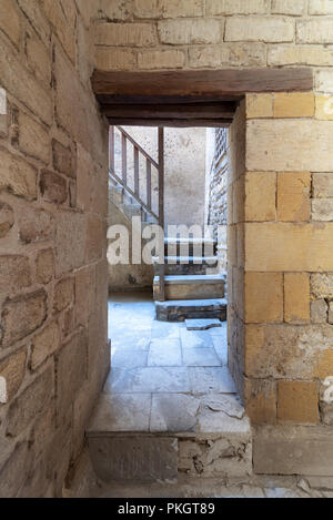 Ancienne anciennes briques externe mur de pierre et la porte révélant un escalier de pierre avec balustrade en bois, vieux Caire, Egypte Banque D'Images