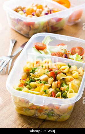 Préparation des repas sains avec des aliments contenants prêts à manger. Salades de pâtes sur la table en bois. Banque D'Images