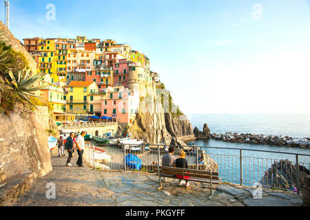 MANAROLA ITALIE - Le 25 avril 2011 ; bateaux arrivés et les personnes ci-dessous couleur village sur une colline escarpée de bâtiments construits sur le roc de la falaise au Cinque Terre o Banque D'Images