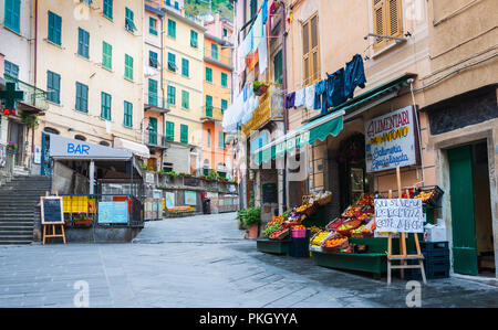 RIOMAGGIORE, ITALIE - 25 avril 2011, Village-rue entre des bâtiments traditionnels scène avec bar, de l'alimentation et les fruits et légumes en Cinque Terr Banque D'Images